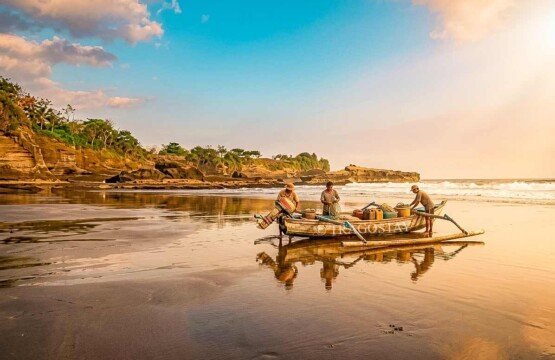 A local Balinese fisherman casting a net on the volcanic shores of Balian Beach.