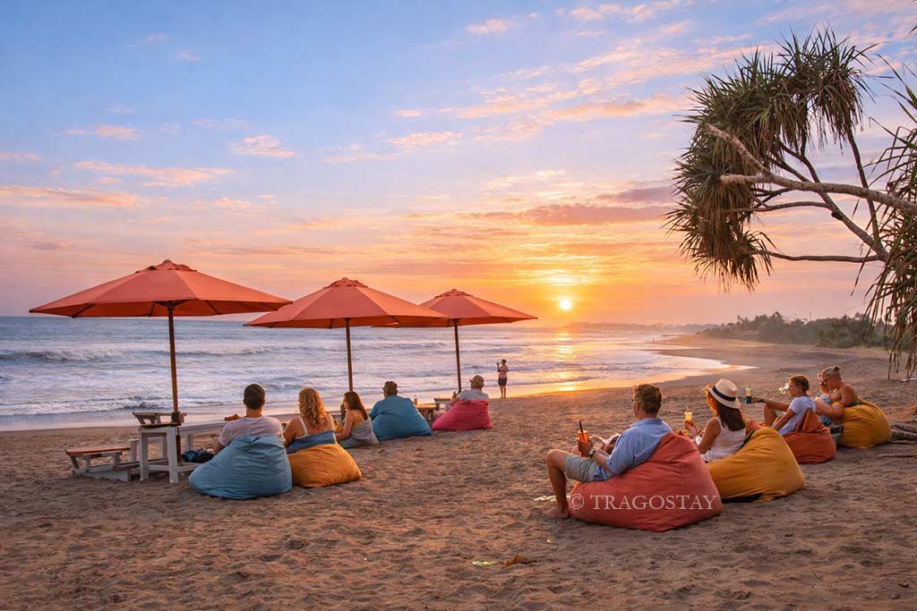 Tourists enjoy a beautiful golden sunset at Berawa Beach Bali.
