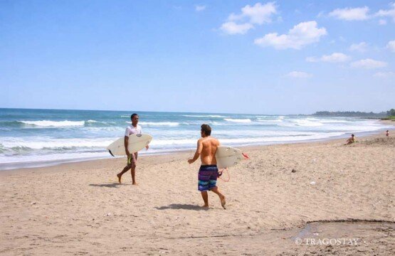 Surfers enjoying the Berawa Beach surf experience at popular Bali tourist attractions.