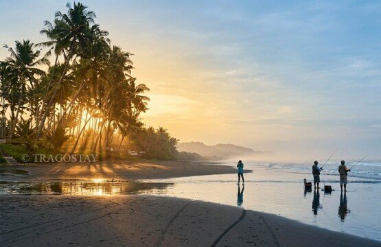A local angler fishing on the edge of Pasut Beach during a bright and sunny morning.