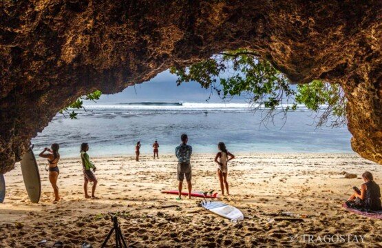 Relaxation in a cave at Green Bowl Beach Bali providing natural shade for tourists.