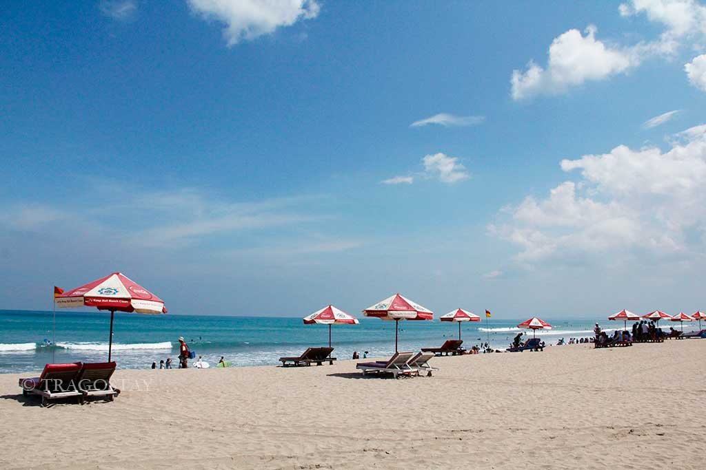 Sunny daytime landscape of Kuta Beach, a premier choice among Bali Tourist Attractions.