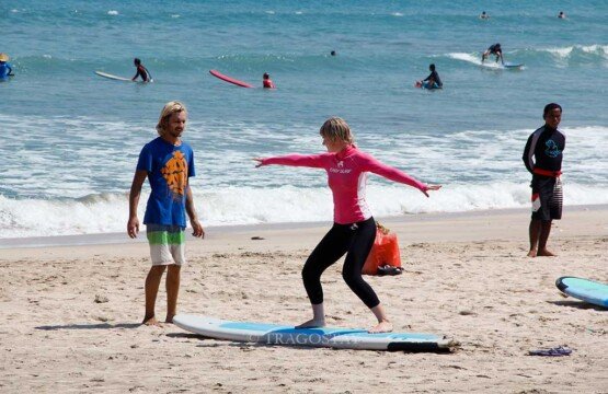 Beginner surfers taking a Kuta Beach surf lesson at Bali Tourist Attractions.