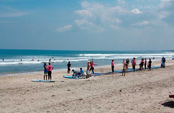 Surfers catching waves at the legendary Kuta Beach surf spot in Bali.