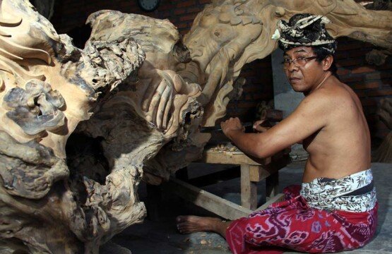 A skilled Mas Village wood carver working on a detailed Balinese wood carving.