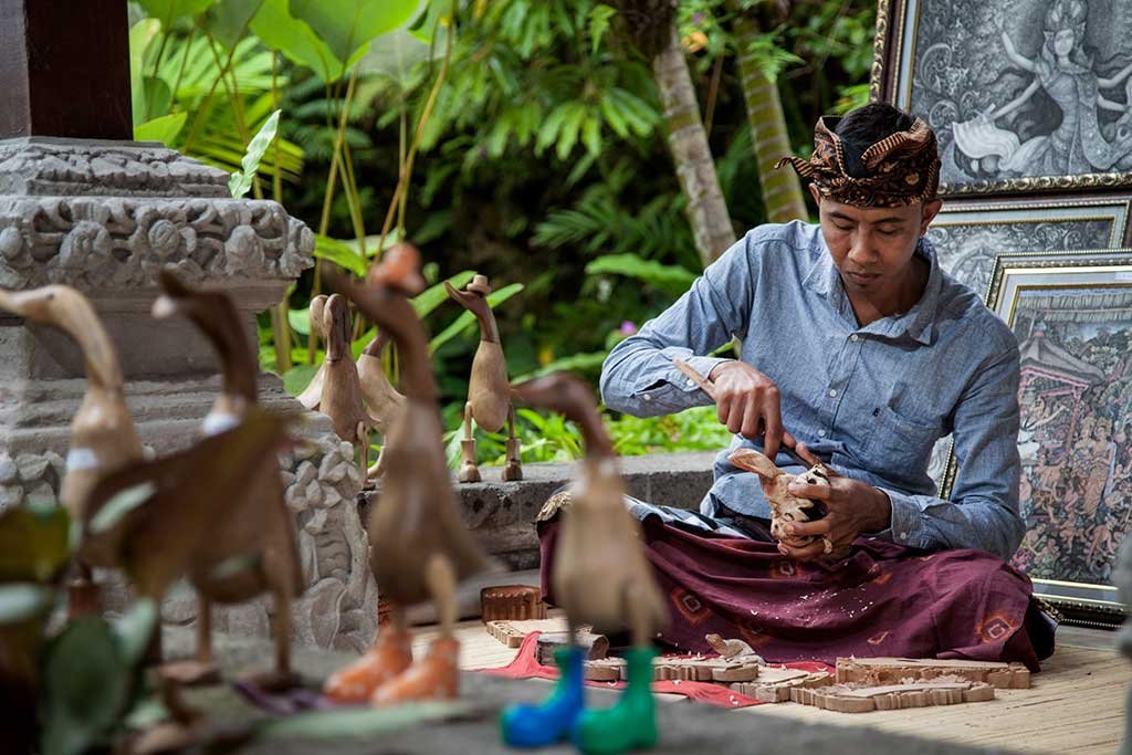Tourists observing a live wood carving activity in Mas Village Ubud.