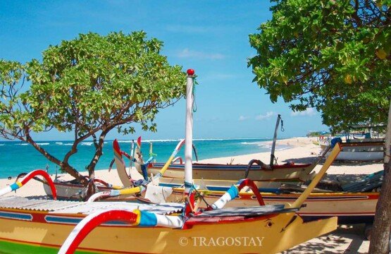 Traditional Balinese wooden boats resting on the shore of Nusa Dua Beach.
