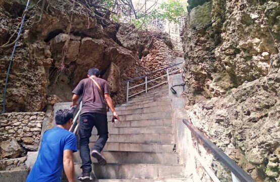Narrow cliff stairs and rock crevice access to Padang-padang Beach Bali.