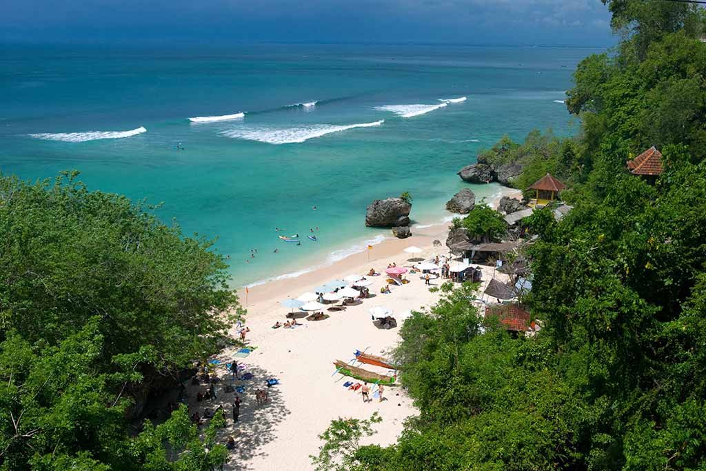 Panoramic Padang-padang Beach overview showing the turquoise bay and limestone cliffs.