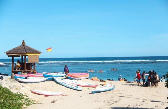 Rows of colorful boats at the canoe rental service at Pandawa Beach for tourists.