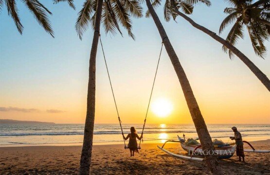 A woman swinging at Pasut Beach next to local fishermen preparing their traditional boats at sunset.