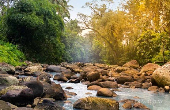 The peaceful river flowing alongside the Penatahan Hot Springs destination.