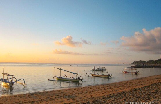 Row of traditional Jukung boats standby at Sanur Beach Bali tourist attractions.