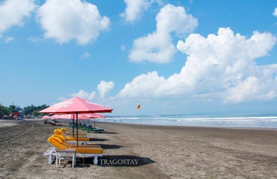 Iconic colorful Seminyak Beach umbrella and bean bags at Bali tourist attractions.