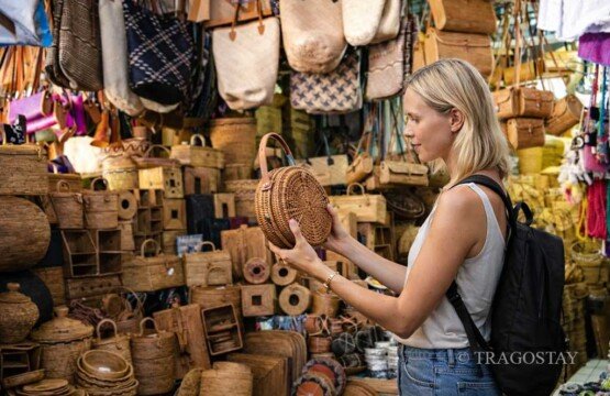 A tourist selecting a handcrafted rotan bag at Sukawati Art Market.