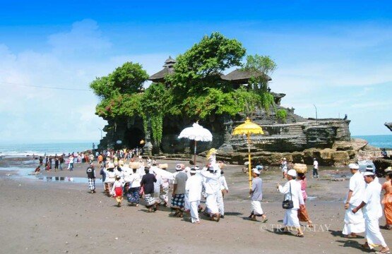 Traditional Balinese Hindu temple ceremony at Tanah Lot Temple, a top tourist attraction.