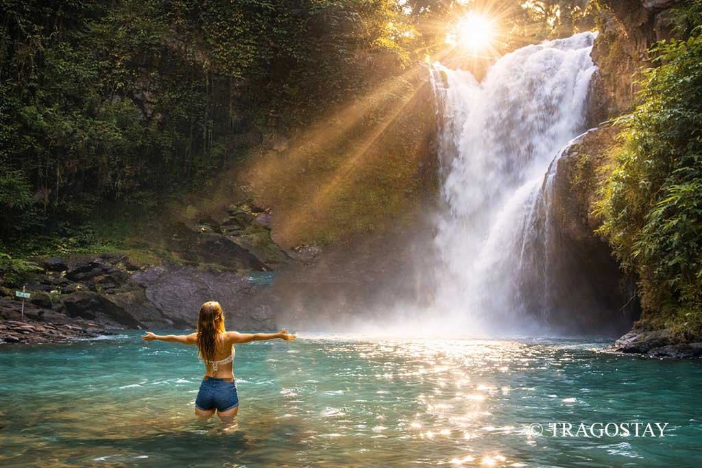 Tourists enjoying fresh bathing at Tegenungan Waterfall, a favorite Bali tourist attraction.