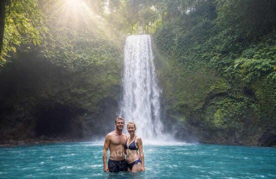Tourists enjoying a fresh bathing and swimming experience at Tibumana Waterfall Ubud Bali.