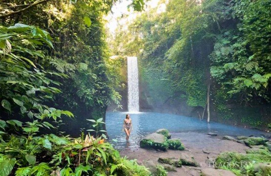 Fertile tropical nature and rainforest surrounding the secluded Tibumana Waterfall in Ubud Bali.
