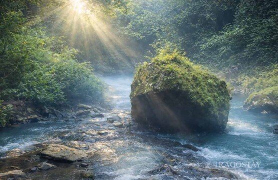 A big natural stone on the riverbed leading to Tibumana Waterfall Bali.