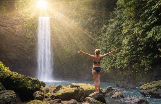 Tourists enjoy a peaceful sunrise experience at Tibumana Waterfall Ubud Bali.