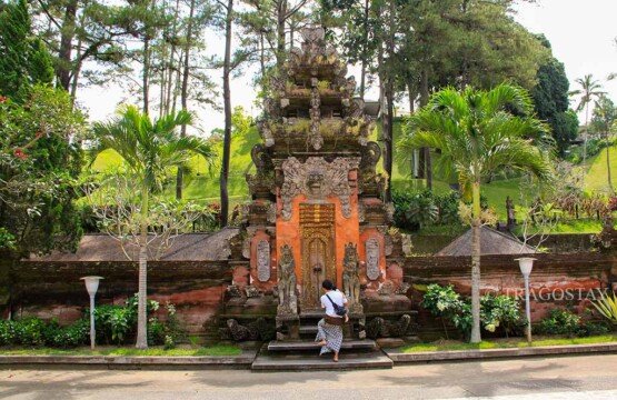 Iconic Balinese entrance gate of Tirta Empul Temple Bali featuring red brick and stone carvings.