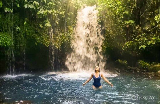 Tourists enjoy bathing in the fresh natural pool at Yeh Hoo Waterfall Bali.