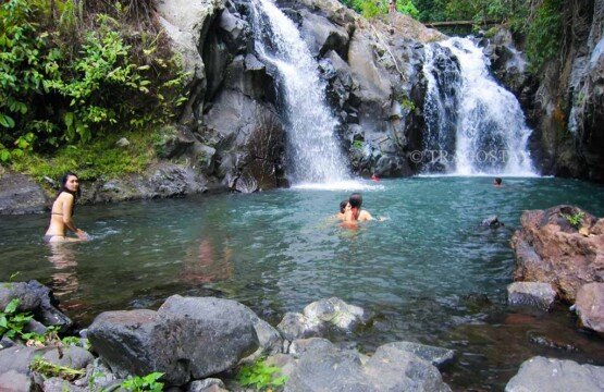 The wide and calm natural rock pool at the base of the twin cascade at Aling-aling Waterfall, ideal for swimming and relaxation.