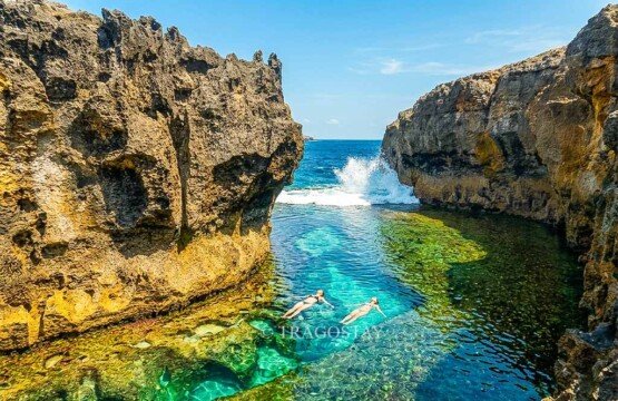 Two international tourists swimming and enjoying the refreshing tropical water at Angel's Billabong.