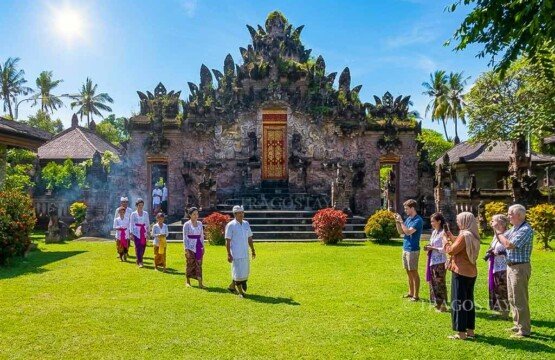 International tourists visiting and exploring the famous architectural grounds of Beji Temple in northern Bali.