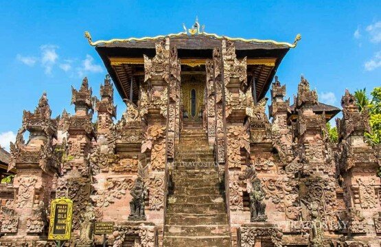 The grand main shrine structure of Beji Temple completely covered in ornate, detailed, and authentic Buleleng-style stone reliefs.