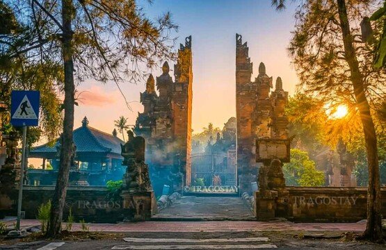 A grand and towering traditional Balinese split gate (Candi Bentar) serving as the main entrance to the historic Beji Temple complex.