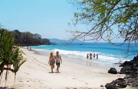 Tourists swimming and walking along the shore during a bright sunny day at Bias Tugel.