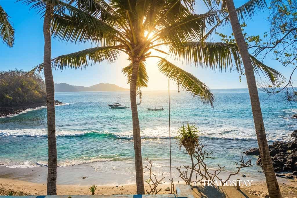 A high-angle scenic overview showing the hidden bay and turquoise waters of Blue Lagoon Beach Padangbai.
