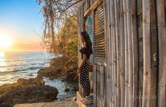 A photographer capturing the golden morning light during a spectacular sunrise at Blue Lagoon Beach Padangbai.