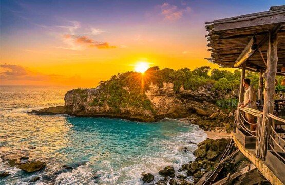 A man enjoying the peaceful atmosphere and bright sunset colors at the edge of Blue Lagoon.