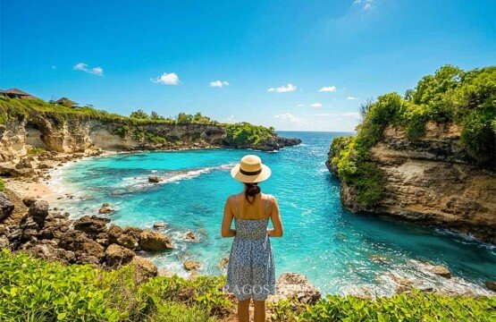 A female tourist standing at the edge of a cliff while gazing at the beauty of Blue Lagoon.