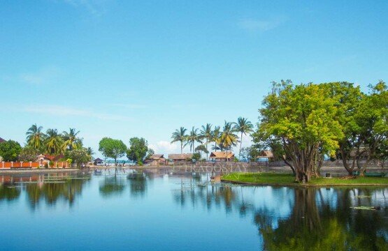 The expansive Lotus Pond in Candidasa with vibrant blue water under a bright blue sky.
