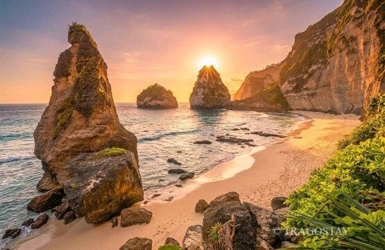 A warm and vibrant sunset sky glowing over the rugged cliffs and ocean at Diamond Beach.