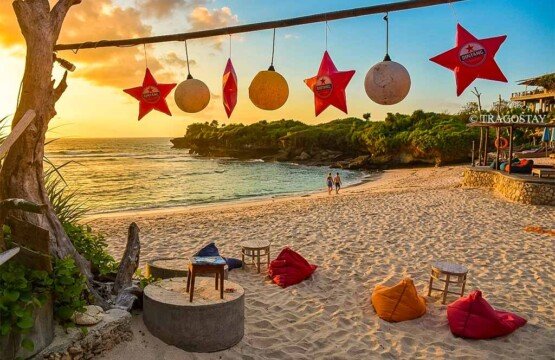 Colorful bean bags arranged by a beachside cafe at Dream Beach during a peaceful sunset.