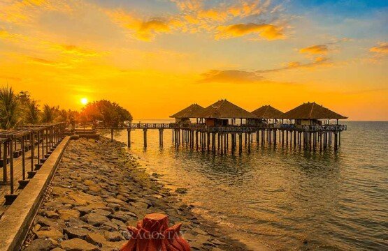 A breathtaking evening sunset casting spectacular gold and orange colors over the historical pier and calm sea at Ex-Buleleng Harbour.