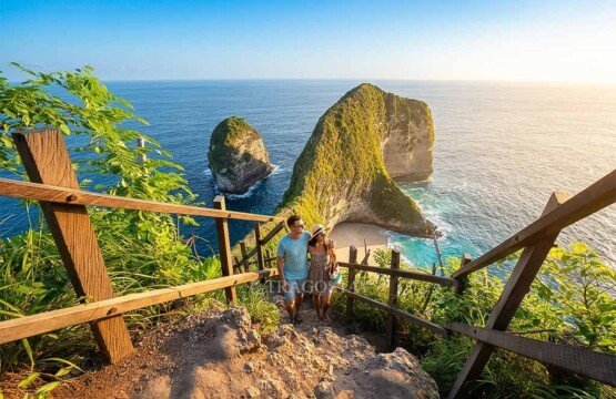 A romantic tourist couple posing on the cliffside pathway to Kelingking Beach during a bright afternoon.