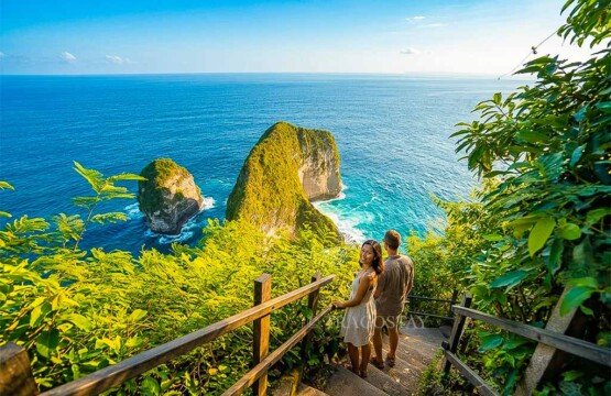 A tourist couple carefully descending the stairs toward Kelingking Beach during a warm and sunny afternoon.