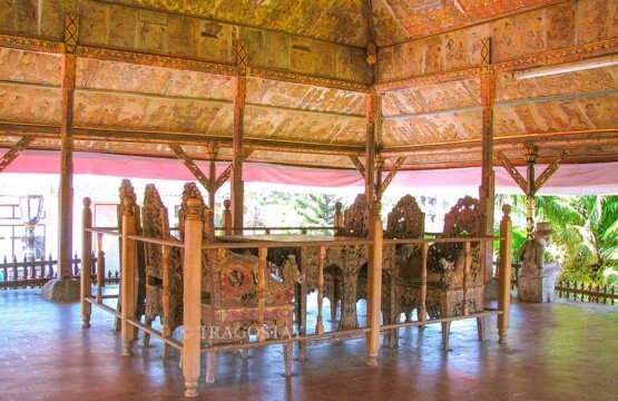 Classic chairs and tables inside the royal court of Kerta Gosa with intricate Kamasan wayang paintings on the ceiling.