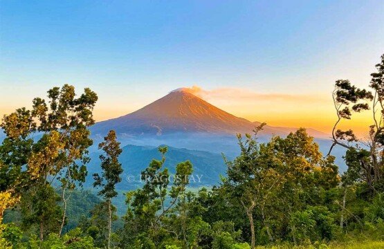 A spectacular overview of the Mount Agung volcano and surrounding valleys during sunrise from Lahangan Sweet.