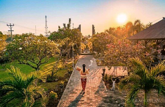 A scenic wide landscape view of the historic Meduwe Karang Temple compound during a peaceful and warm late afternoon.