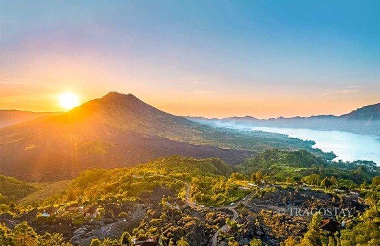 A panoramic sunrise overview of Mount Batur and the calm waters of Lake Batur taken from Penelokan, Kintamani.