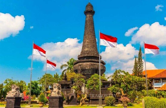 The Puputan Klungkung Monument on a bright day with several Indonesian Red and White flags waving in the breeze.