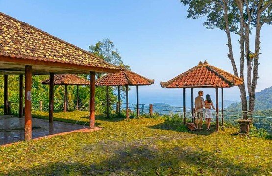 A happy tourist couple standing at a viewpoint enjoying the fresh air and stunning nature of Putung Hill.