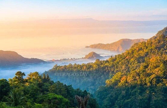 A breathtaking morning view from Putung Hill overlooking lush green valleys and the distant blue ocean.